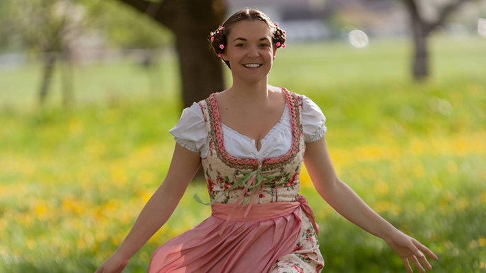 Frau im Dirndl auf einer Wiese