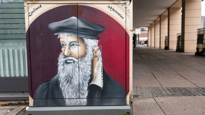Ein Bild von Gerhard Mercator ist auf einen Fernmeldekasten neben dem Mercator-Haus in der Innenstadt von Duisburg gesprüht