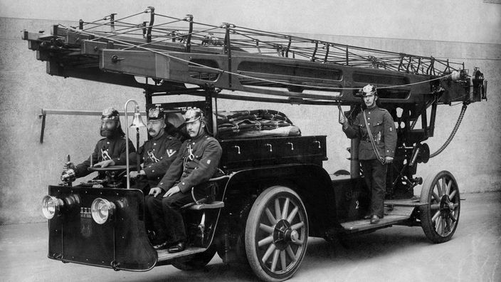 Historische Aufnahme von 1907: Feuerwehrmänner auf einem Löschwagen