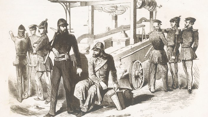 Auf der schwarzweißen Zeichnung sieht man mittig einen hölzernen Wagen mit Feuerwehrspritzen. Drumherum stehen sieben uniformierte Männer, der achte sitzt im Vordergrund.