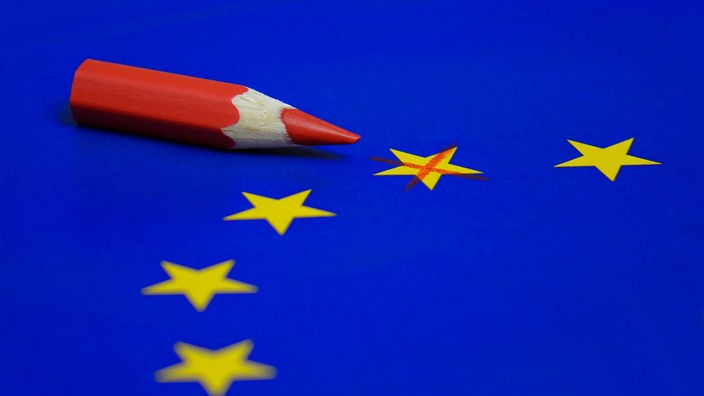 Symbolfoto: Auf einer EU-Flagge liegt ein Rotstift. Ein Stern der Flagge ist angekreuzt.