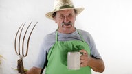 Motivbild: Ein Landwirt mit Mistgabel und Bierkrug in der Hand.