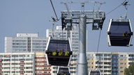 Seilbahn vor einer Hochhauskulisse im Hintergrund.
