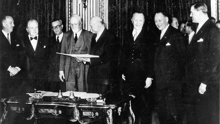 Schwarzweiß-Foto der Außenminister von Deutschland, Frankreich, Italien und der Benelux-Länder, die sich nach der Vertragsunterzeichnung über die Europäische Gemeinschaft für Kohle und Stahl am 18. April 1951 zu einem Gruppenbild aufgestellt haben.