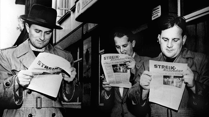 Streikende Arbeiter lesen die "Streik-Nachrichten", 1956