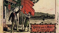 Auf einer alten Postkarte hissen zwei Männer eine rote Fahne. Darunter steht "Gruss zum 1. Mai 1900"