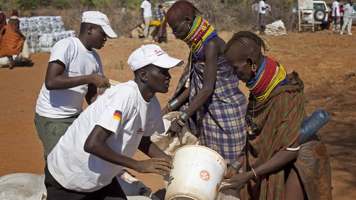 Mitarbeiter der Johanniter Unfallhilfe geben in Nordkenia Getreide an Einheimische aus