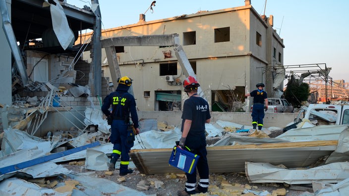Einsatzkräfte in den Trümmern eines zerstörten Gebäudes