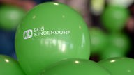 Logo von SOS Kinderdorf auf einem grünen Luftballon