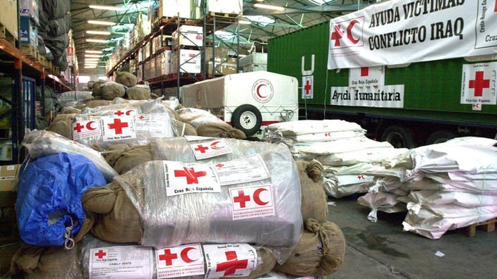 Hilfsgüter mit dem Roten Kreuz und dem Roten Halbmond versehen liegen in einer Halle zum Transport bereit. (Aufnahme: 28.03.2003)