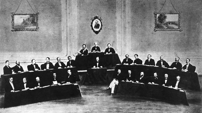Die erste Internationale Konferenz des Roten Kreuzes in Genf im August 1864, in der die Genfer Konvention zwischen den beteiligten Mächten abgeschlossen wurde. Oben das Bild Henry Dunants.