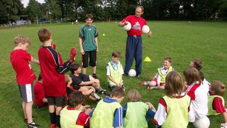 Fußball AG: Kinder zwischen neun und 12 erhalten Trainingseinheiten  von einem Übungsleiter.