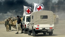 Irakkrieg: Wagen des Internationalen Roten Kreuzes halten an einem Kontrollpunkt der britischen Truppen