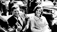 schwarz-weiß-Aufnahme von John F. Kennedy im Auto.