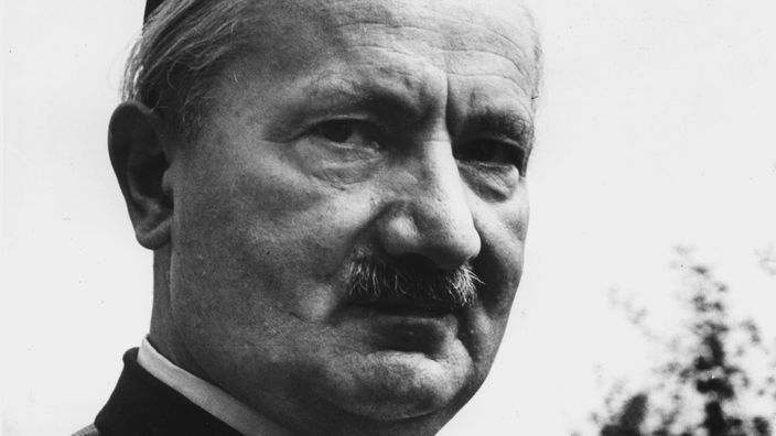 Schwarzweiß-Foto von Martin Heidegger mit Schnurrbart und Trachtenjacke.