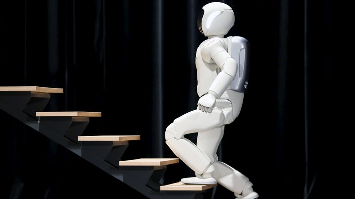 Der weiße Roboter "Asimo" steigt eine Treppe hinauf