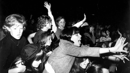 Kreischende Frauen während eines Beatles-Konzerts.