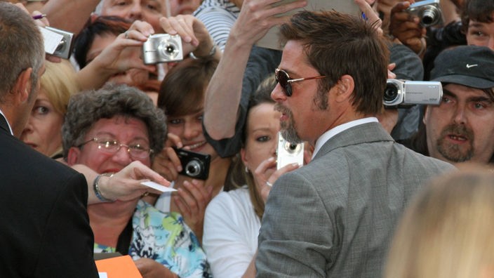 Am roten Teppich fragen Fans Brad Pitt nach Autogrammen.
