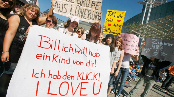 Tokio-Hotel-Fans mit großen Plakaten vor der Konzerthalle.