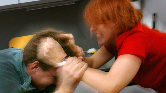 Eine Frau zerrt während eines Streits an den Haaren ihres Partners.