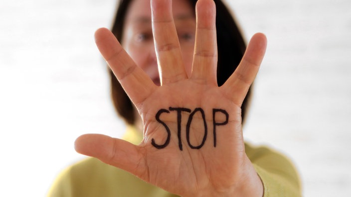 Frau hält Hand mit ausgetreckten Fingern vor sich hoch. Auf der Hand steht in Großbuchstaben: Stop. | Bildquelle: SWR/Imago Frau hält Hand mit ausgetreckten Fingern vor sich hoch. Auf der Hand steht in Großbuchstaben: Stop.