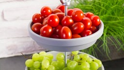 Tomaten und Weintrauben sind auf einer Etagere angerichtet.
