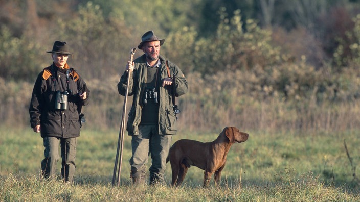 Zwei Jäger mit Jagdhund