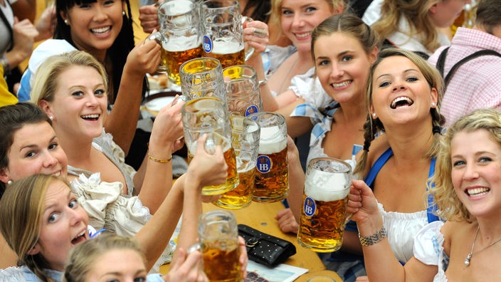Junge Frauen mit Bierkrügen in einem Festzelt auf dem Oktoberfest