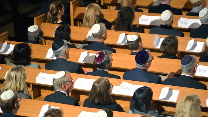 Jüdische Menschen sitzen in einer Synagoge.