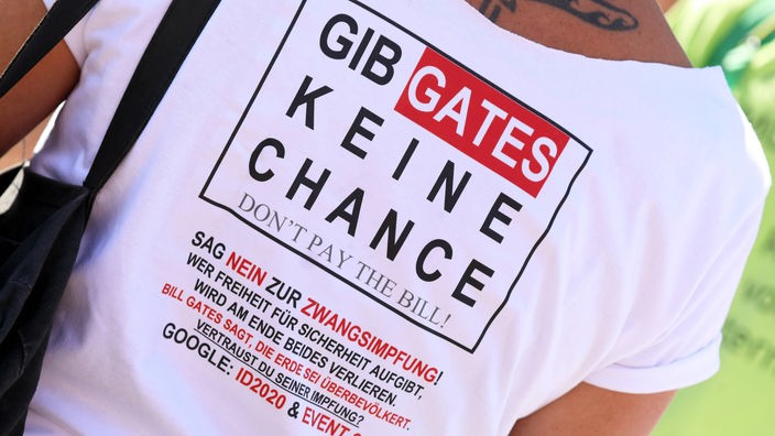 Mann trägt ein weißes T-Shirt auf dem "Gib Gates keine Chance" steht