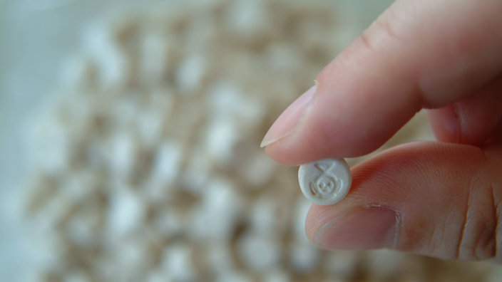 Zwei Finger halten eine Ecstasy-Tablette. | Bildquelle: WDR/imago Zwei Finger halten eine Ecstasy-Tablette.