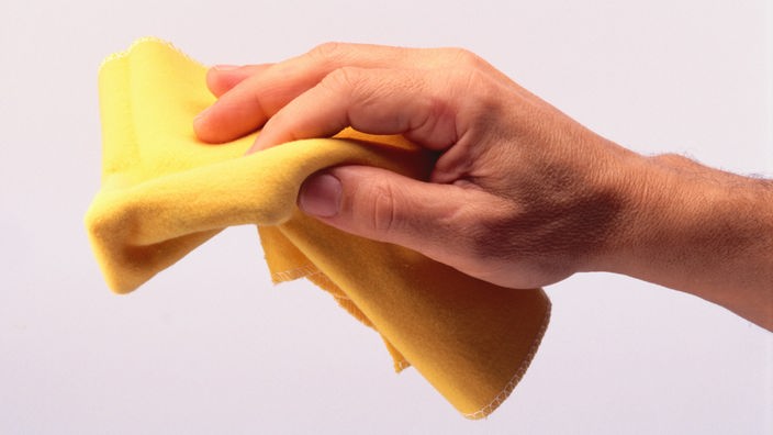 Hand mit gelbem Staubtuch