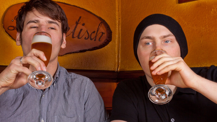 Zwei junge Männer trinken Bier.