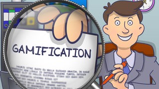 Gezeichneter Mann im Anzug hält ein Papier mit der Überschrift "Gamification" vor eine Lupe.