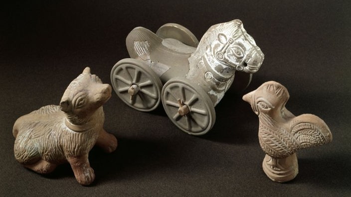 Antikes Tonspielzeug aus Griechenland. Ein Hund, ein Hahn und ein Pferd auf Rollrädern.