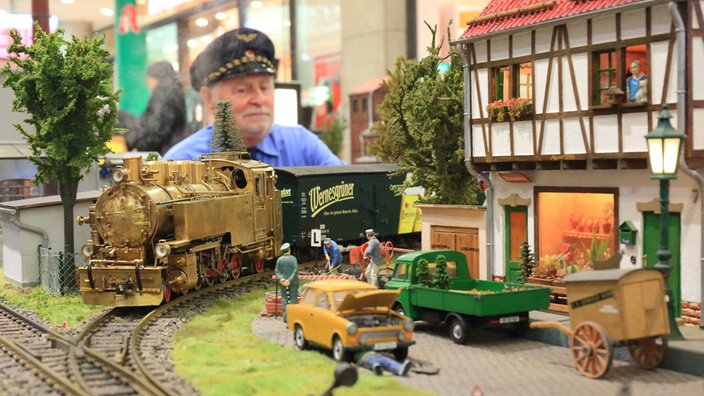Ein Mann betrachtet eine Modelleisenbahn. | Bildquelle: dpa/Jens Wolf Ein Mann betrachtet eine Modelleisenbahn.
