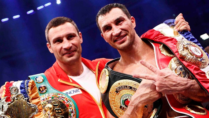 Wladimir und Vitali Klitschko mit Weltmeistergürteln | Bildquelle: Reuters/KAI PFAFFENBACH Wladimir und Vitali Klitschko mit Weltmeistergürteln