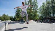 Junger Mann führt Sprung mit Skateboard durch