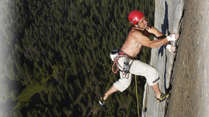 Ein Mann mit Kletterausrüstung klettert eine Steile Wand hoch. | Bildquelle: SWR Ein Mann mit Kletterausrüstung klettert eine Steile Wand hoch.