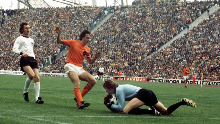 Spielszene aus dem Finale: Sepp Maier hat gerade einen Ball vor den heranstürmenden Johan Cruyff und Franz Beckenbauer gefangen. | Bildquelle: dpa Spielszene aus dem Finale: Sepp Maier hat gerade einen Ball vor den heranstürmenden Johan Cruyff und Franz Beckenbauer gefangen.