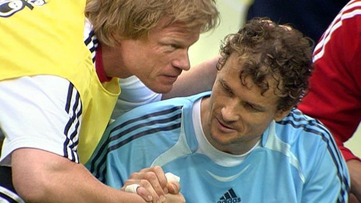 Oliver Kahn macht vor dem Elfmeterschießen mit Jens Lehmann 'shake hands' und tätschelt ihm mit der anderen Hand den Kopf.