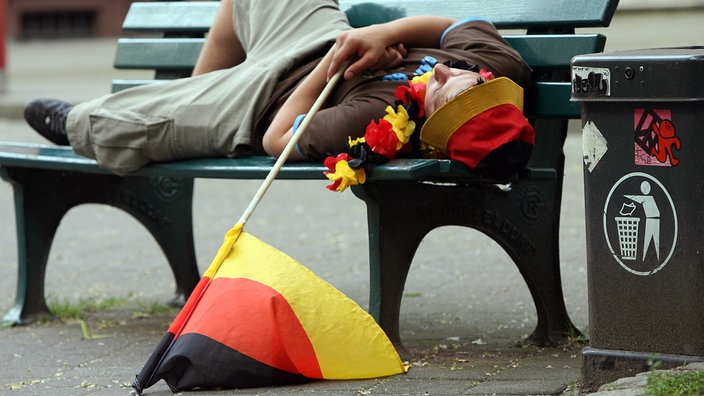 Deutschland-Fan schläft auf eienr Parkbank | Bildquelle: dpa/Martin Gerten Deutschland-Fan schläft auf eienr Parkbank