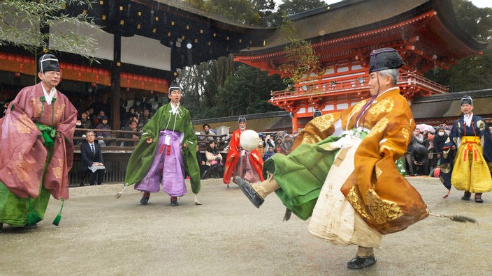 Ältere Japaner in Kimonos spielen Kemari