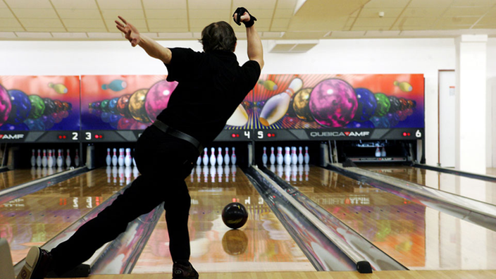 Mann von hinten beim Bowling. | Bildquelle: Mauritius Mann von hinten beim Bowling.