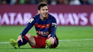 Lionel Messi sitzt auf dem Boden.