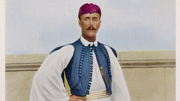Farbige Abbildung von dem Griechen Spiridon Louis, der eine weiße Tracht mit blauer Weste und Stiefel trägt.