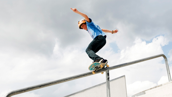 Skater rutscht auf Geländer herunter.