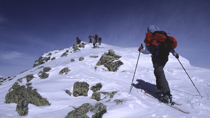 Langläufer auf einem Berggrat.