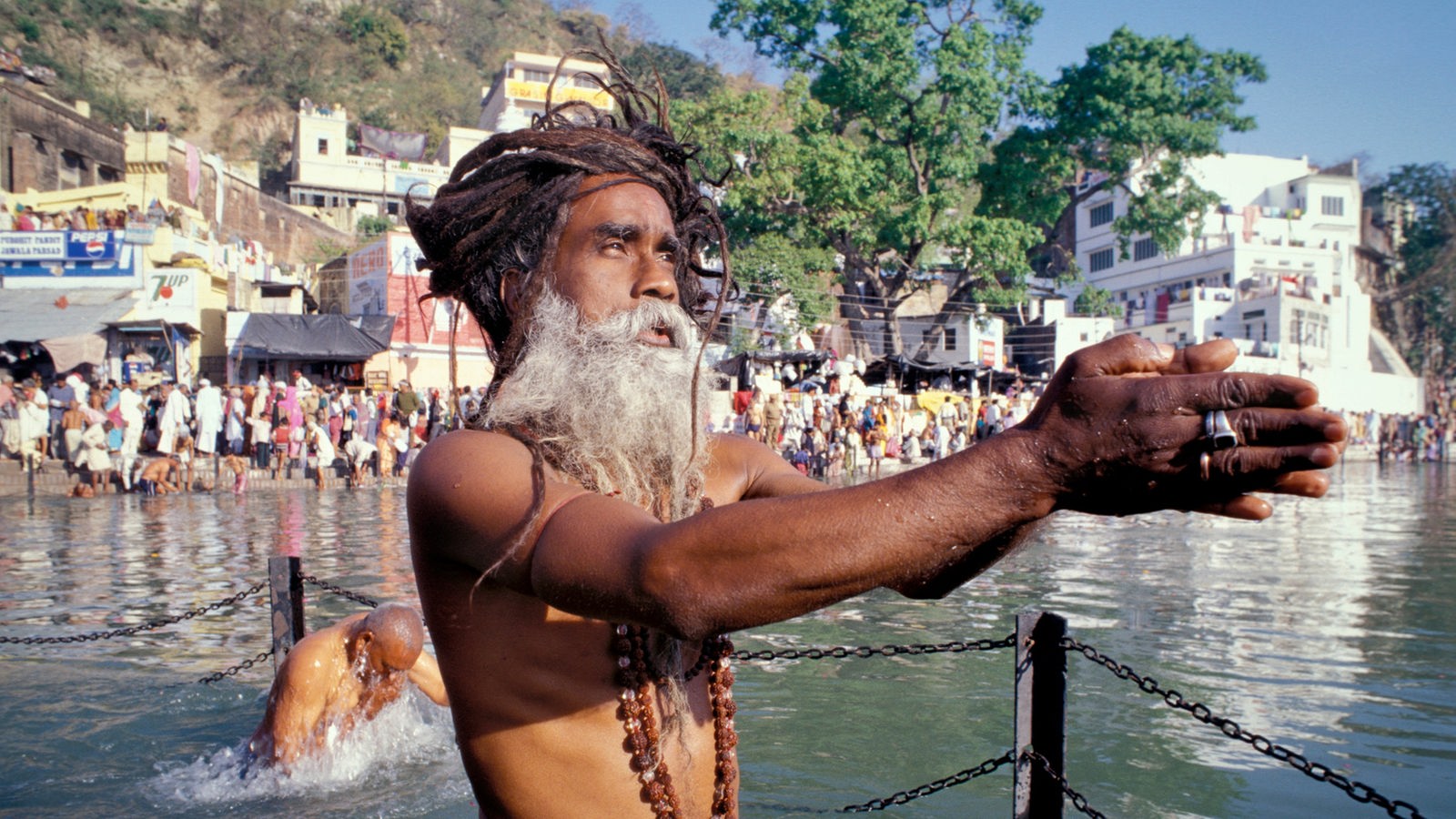 Ein älterer Mann steht im Fluss Ganges