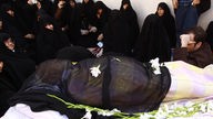 Moslems umringen einen Leichnam, dieser ist ein durchsichtiges Tuch gewickelt